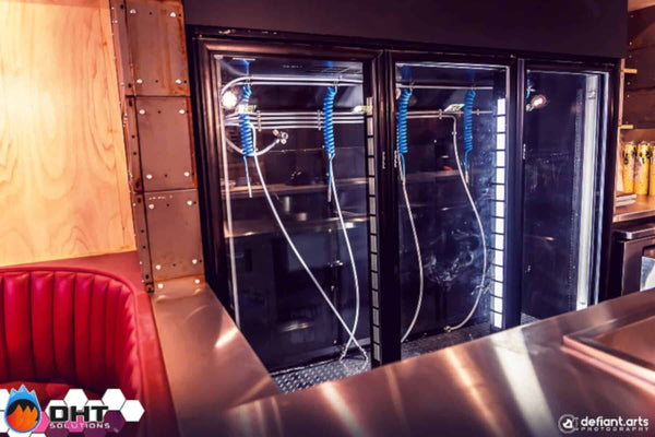 Three glass-door upright fridges set up as keg fridges behind the front bar