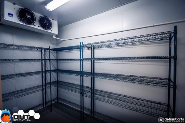The walk-in cool room with wire shelving and a ceiling evaporator
