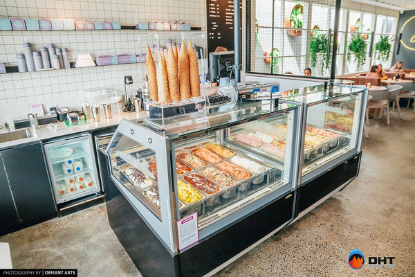 Gelato display cabinet at the counter, with waffle cones stacked on top