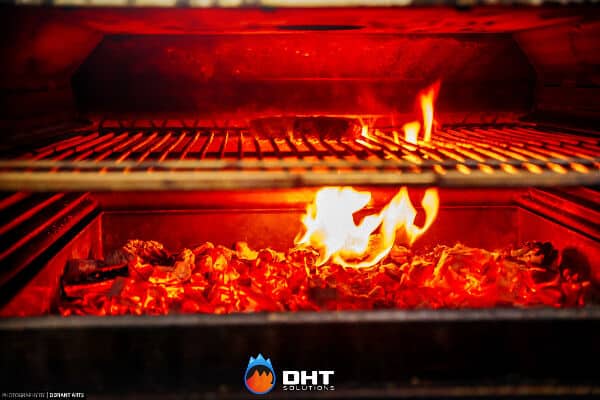 Open flame and glowing charcoal burning in the base of the Josper charcoal oven below the grill bars