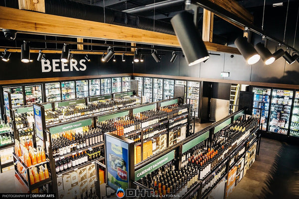 The shop floor from above, with the glass-door beer wall behind the wine aisles