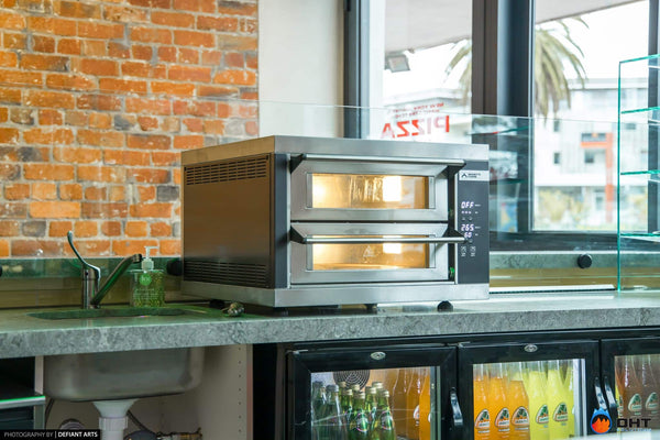 Moretti Forni twin-deck pizza oven on the counter above glass-door drinks fridges